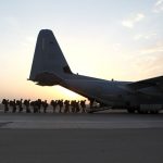 A military plane with troops getting on board